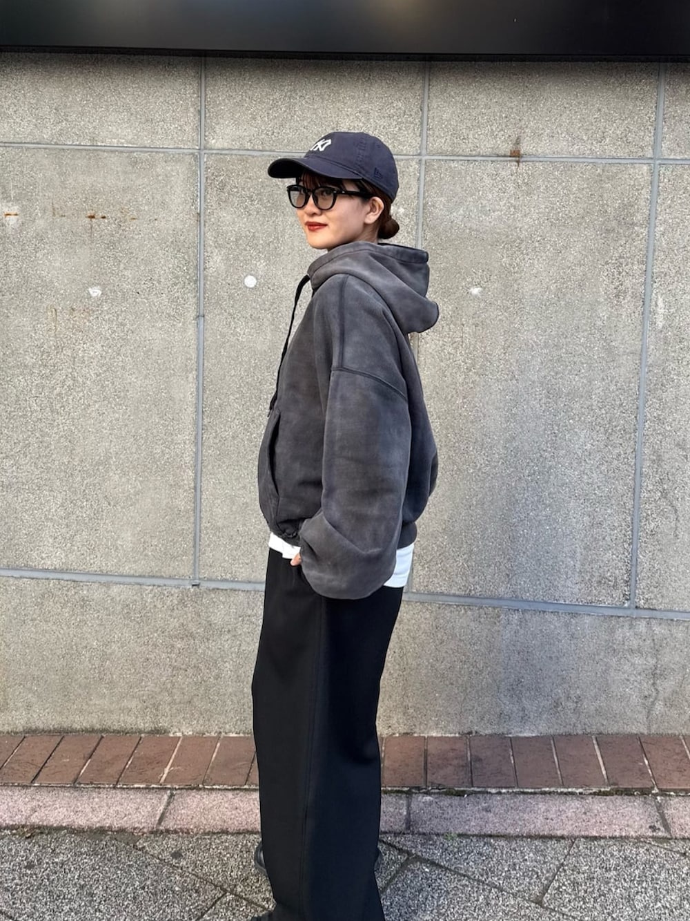 ブラック系のパーカー、ブラック系のスラックス、ブラック系のサングラスを着用したレディースの冬コーディネートの3枚目の写真