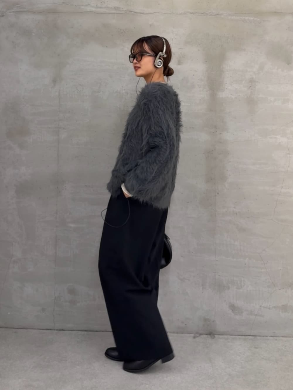 グレー系のカーディガン/ボレロ、ホワイト系のニット/セーター、ブラック系のスラックスを着用したレディースの秋コーディネートの4枚目の写真