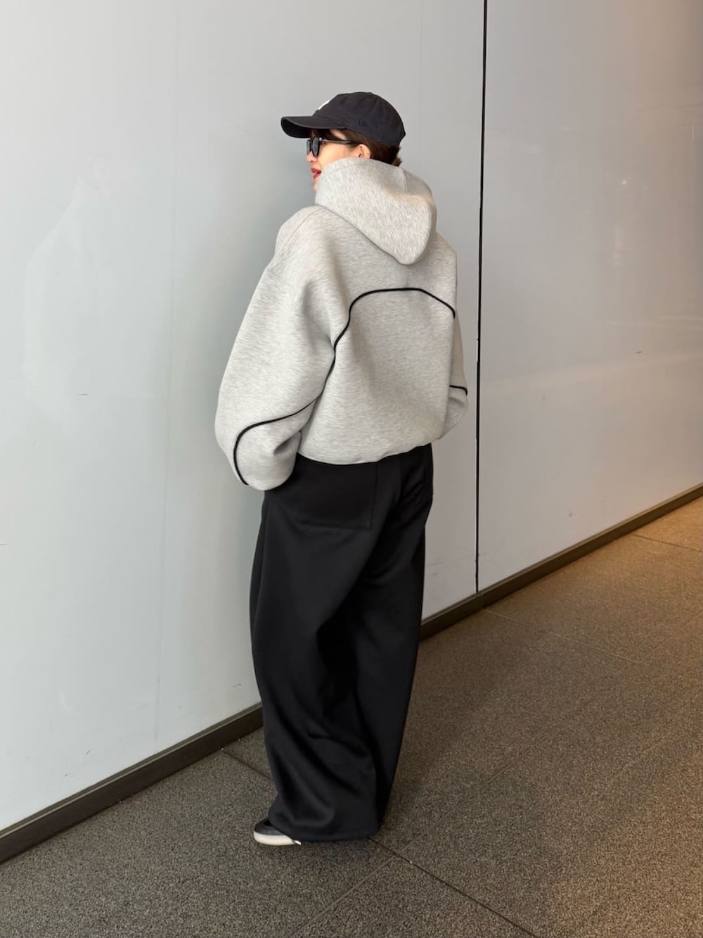 グレー系のパーカー、グレー系のその他パンツ、ブラック系のサングラスを着用したレディースの春コーディネートの7枚目の写真