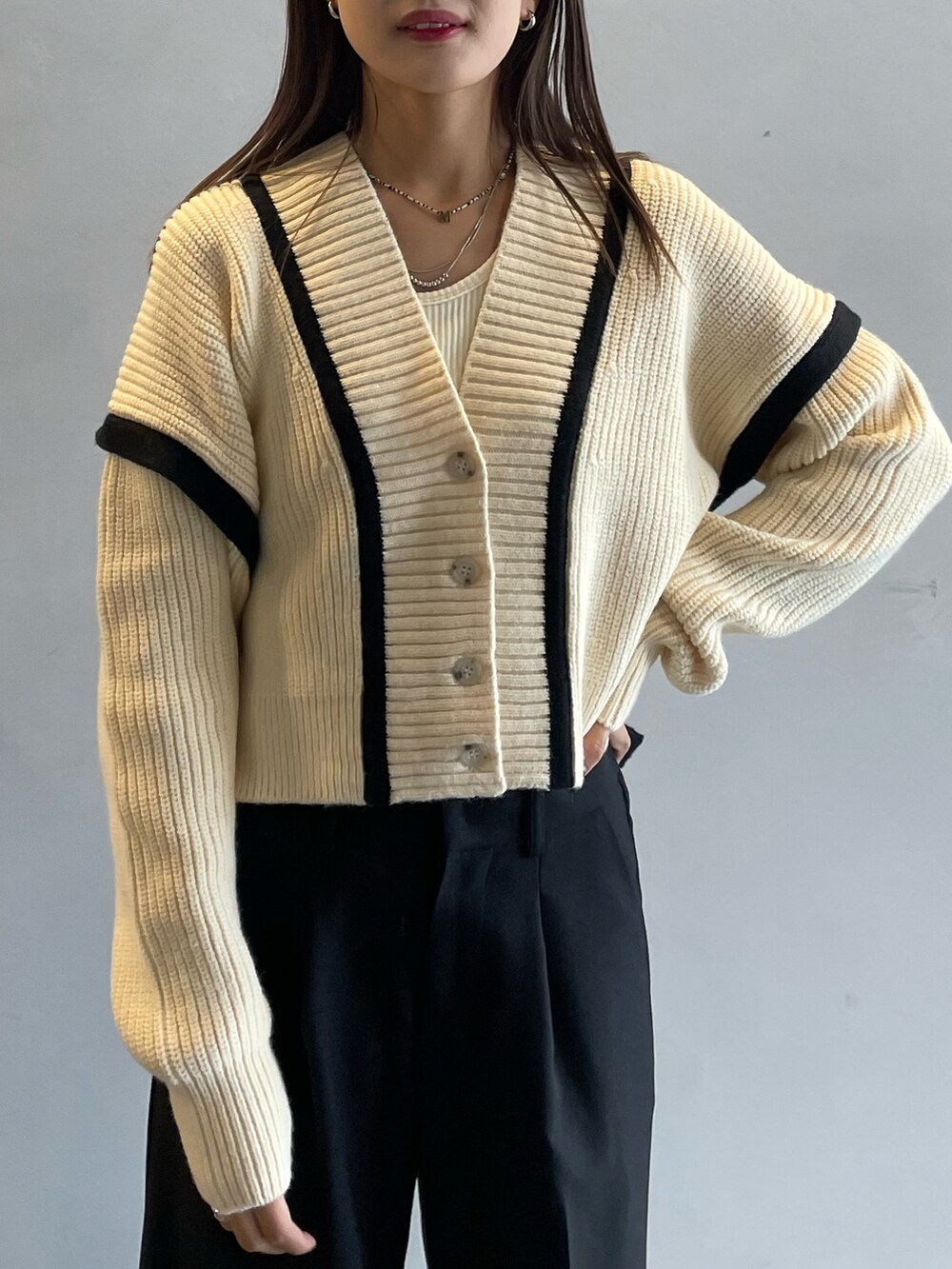 ホワイト系のカーディガン/ボレロ、ホワイト系のキャミソール、ブラック系のその他パンツを着用したレディースの秋コーディネートの4枚目の写真