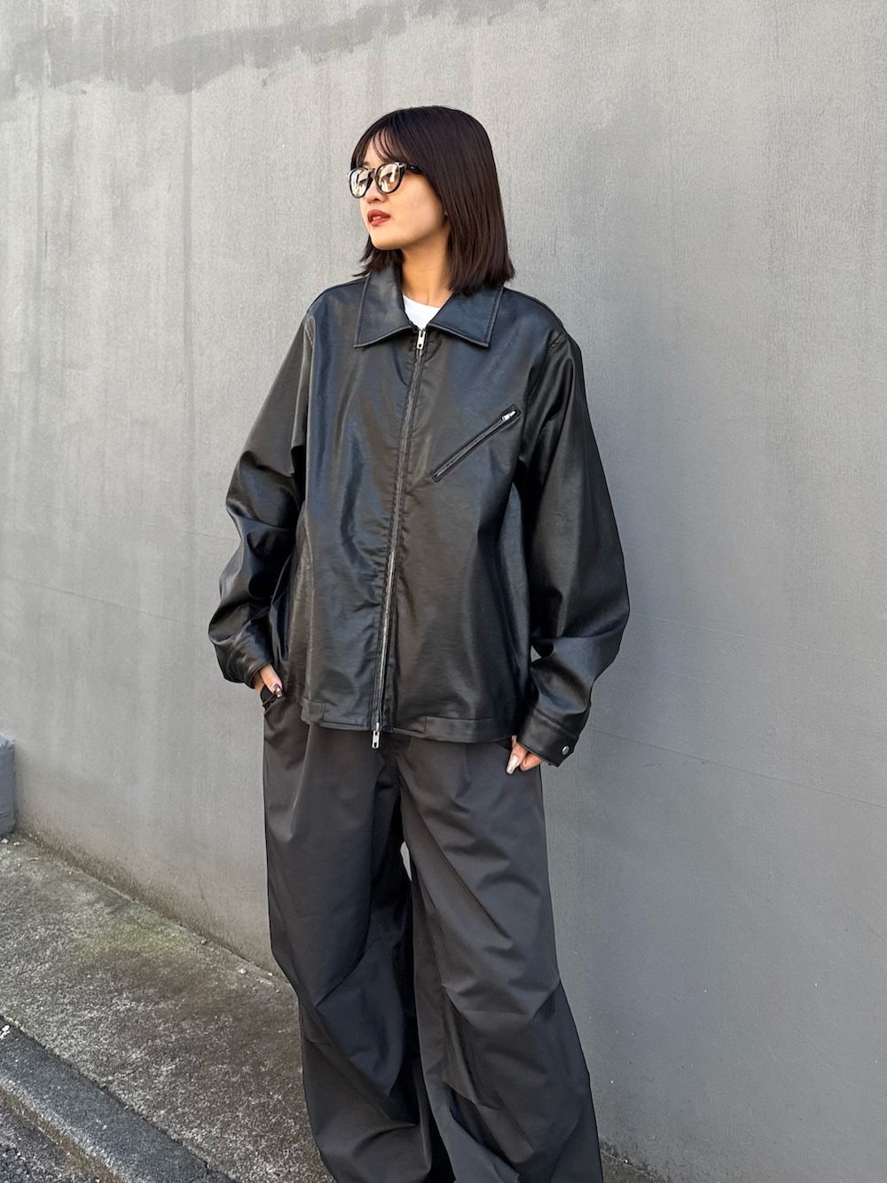 ブラック系のブルゾン、ホワイト系のその他パンツを着用したレディースの秋コーディネートの2枚目の写真