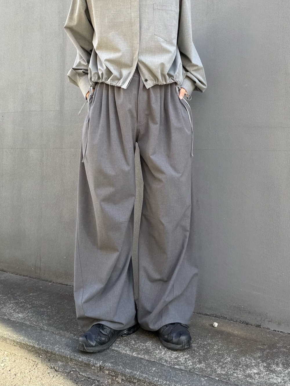 グレー系のスラックス、グレー系のシャツ/ブラウス、ブラック系のサングラスを着用したレディースの冬コーディネートの3枚目の写真