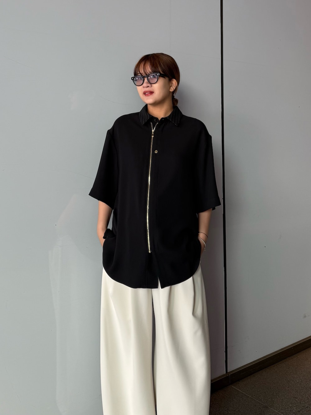 ブラック系のシャツ/ブラウス、グレー系のスラックスを着用したレディースの春コーディネートの4枚目の写真