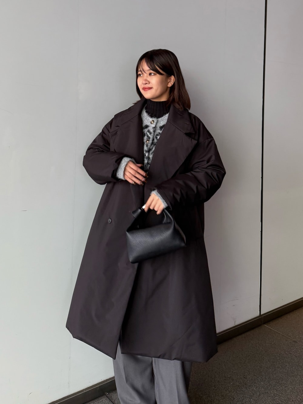 ブラック系のカーディガン/ボレロ、ブラック系のチェスターコート、ブラック系のトートバッグを着用したレディースの秋コーディネートの2枚目の写真