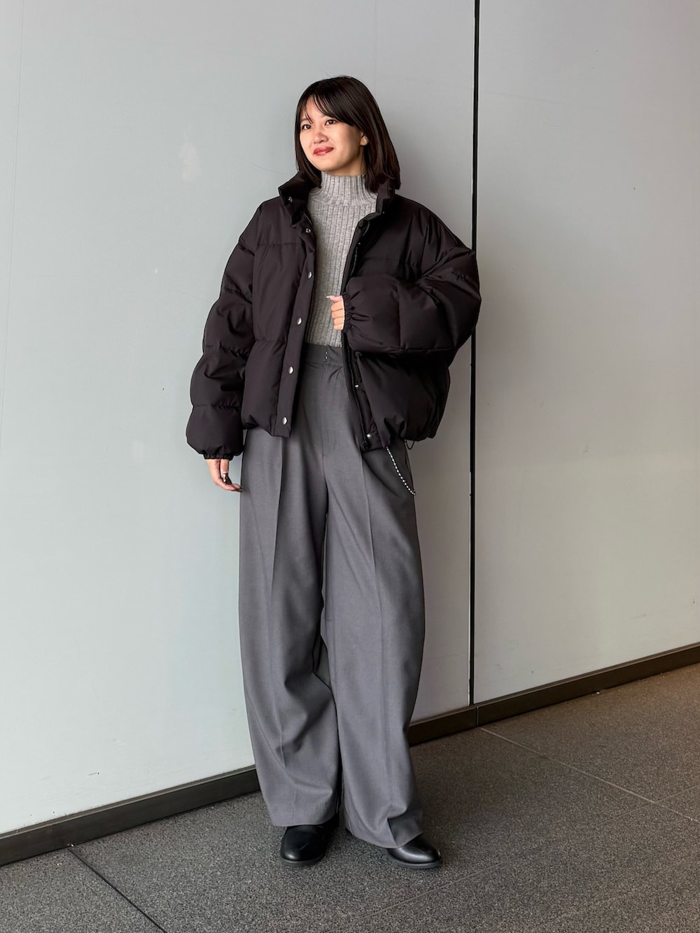 ホワイト系のダウンジャケット/コート、グレー系のスラックス、ブラック系のTシャツ/カットソーを着用したレディースの秋コーディネートの6枚目の写真