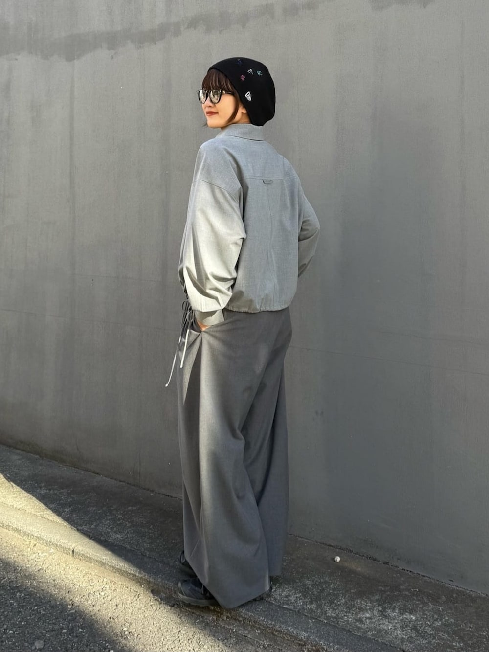 グレー系のスラックス、グレー系のシャツ/ブラウス、ブラック系のサングラスを着用したレディースの冬コーディネートの5枚目の写真