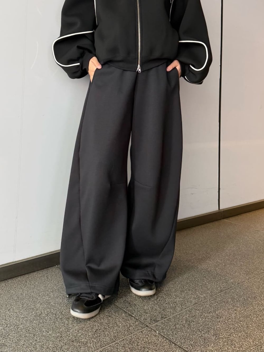 グレー系のその他パンツ、グレー系のパーカー、ブラック系のサングラスを着用したレディースの春コーディネートの3枚目の写真