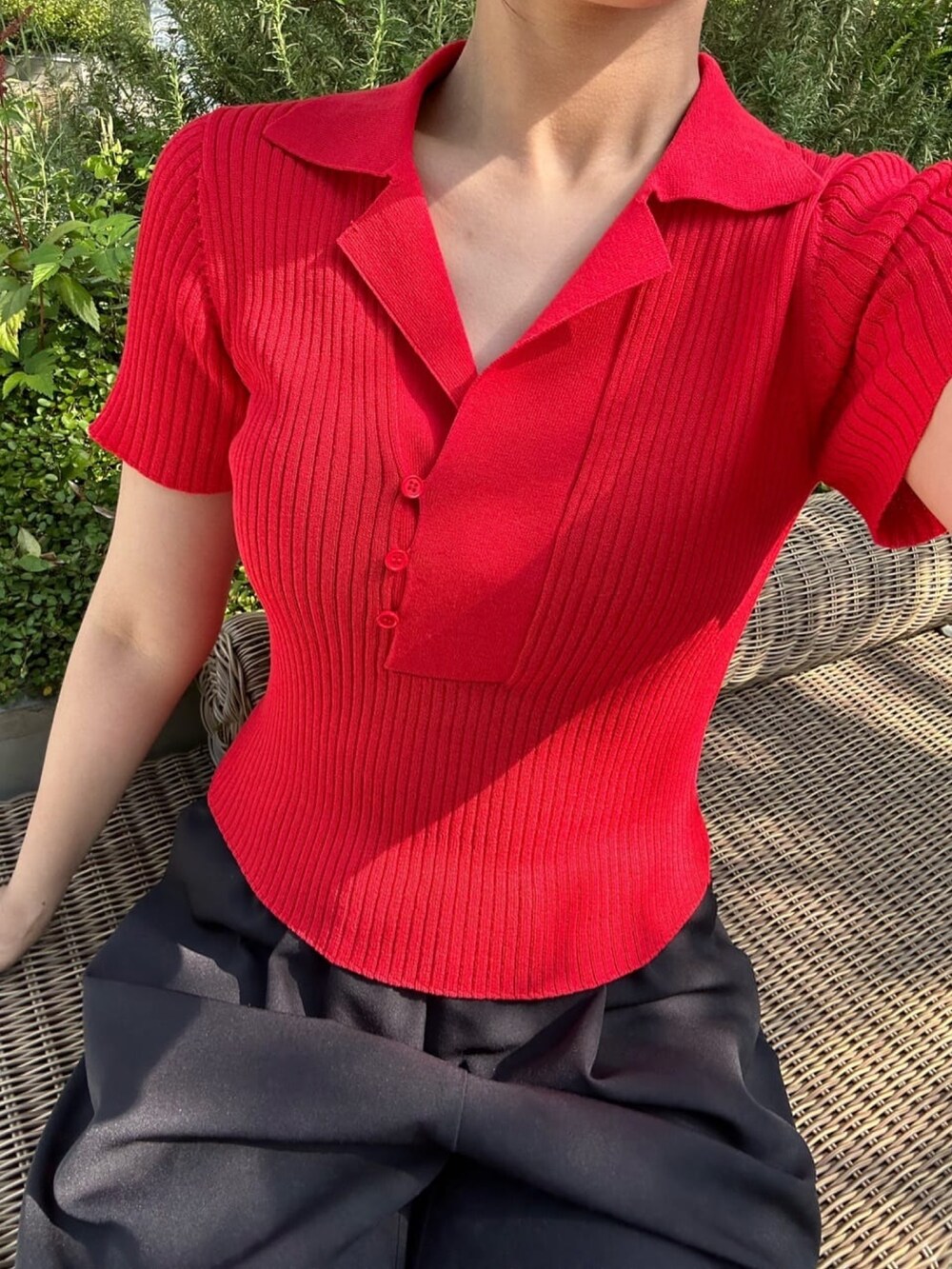 レッド系のニット/セーター、グレー系のパンツ、グレー系のサングラスを着用したレディースの夏コーディネートの3枚目の写真