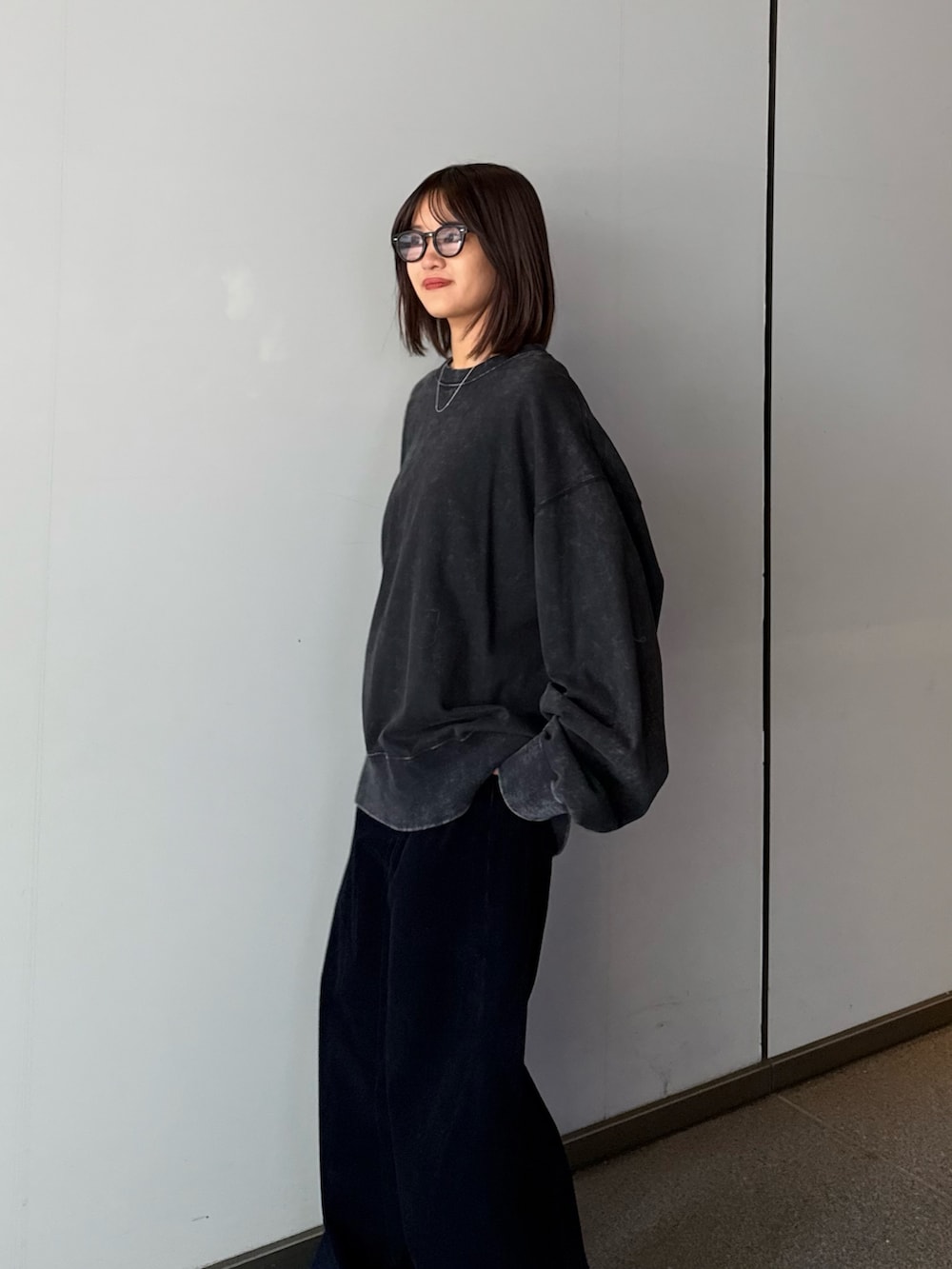 ブラック系のスウェット、ブルー系のその他パンツ、ブラック系のサングラスを着用したレディースの秋コーディネートの5枚目の写真