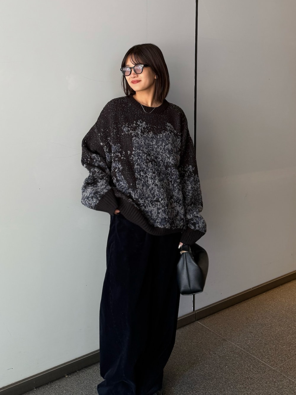 ブラック系のニット/セーター、ブラック系のトートバッグ、ブルー系のその他パンツを着用したレディースの秋コーディネートの5枚目の写真