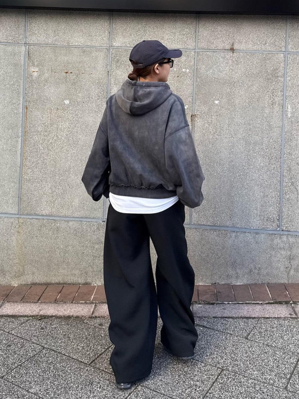 ブラック系のパーカー、ブラック系のスラックス、ブラック系のサングラスを着用したレディースの冬コーディネートの6枚目の写真