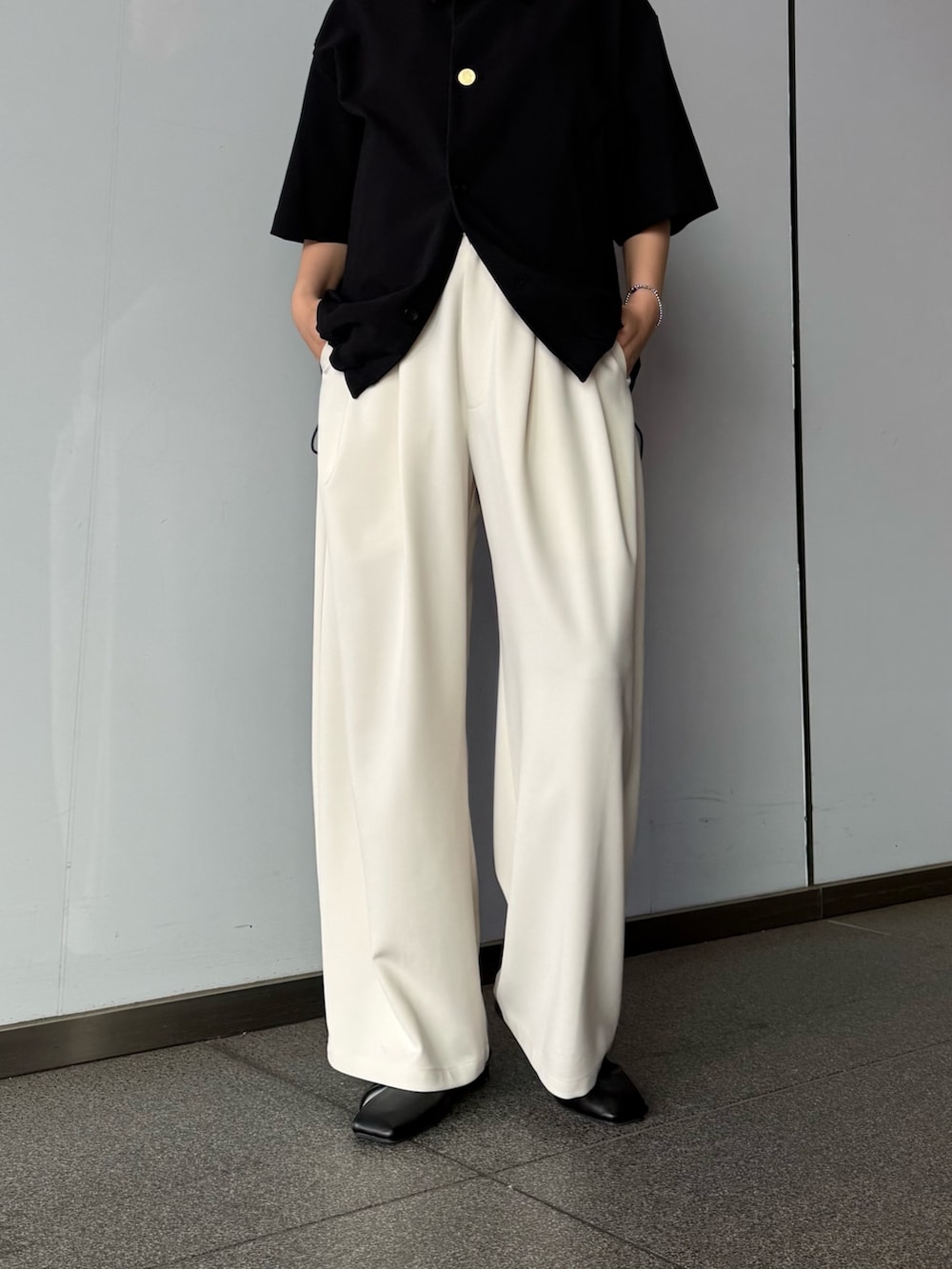 ブラック系のシャツ/ブラウス、グレー系のスラックスを着用したレディースの春コーディネートの4枚目の写真