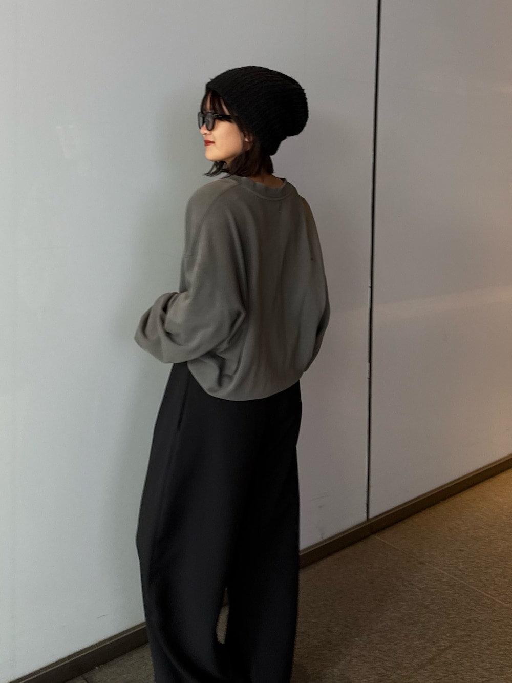 ブラック系のスラックス、ブラック系のスウェット、ブラック系のサングラスを着用したレディースの秋コーディネートの4枚目の写真