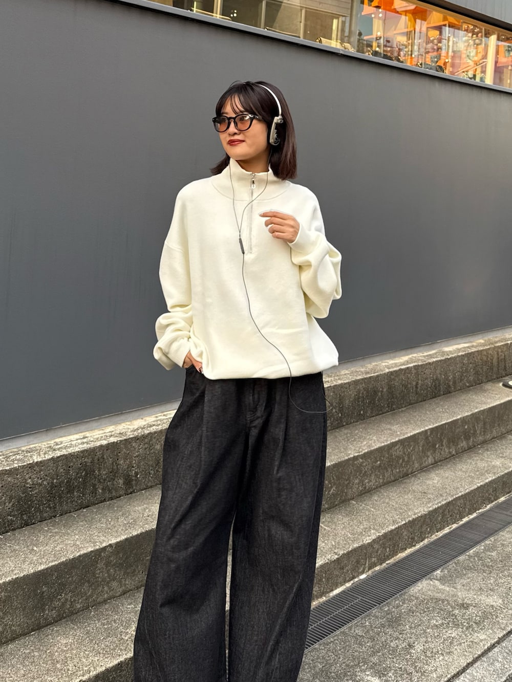 ホワイト系のニット/セーター、ブラック系のデニムパンツを着用したレディースの秋コーディネートの6枚目の写真