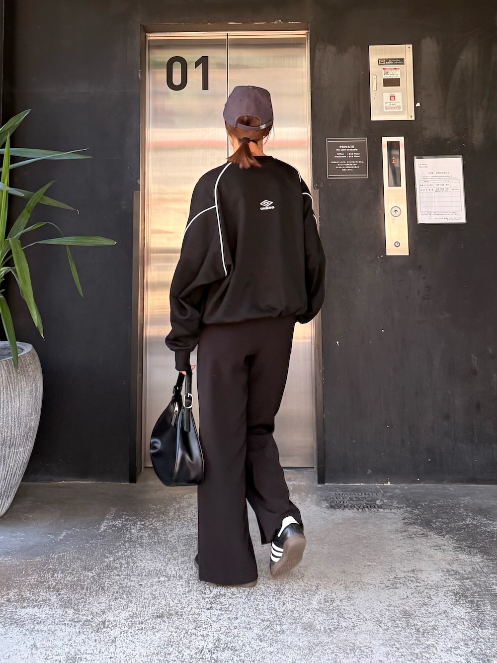 ブルー系のスウェット、ブラック系のハンドバッグ、ブラック系のサングラスを着用したレディースの冬コーディネートの5枚目の写真