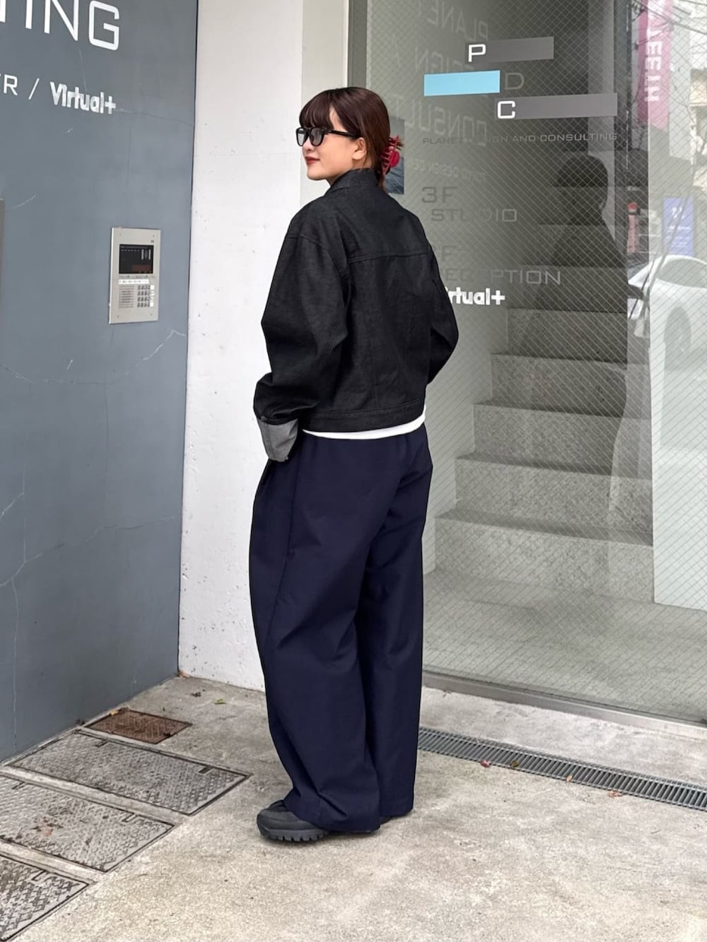 ブルー系のその他パンツ、ブラック系のデニムジャケット、ブラック系のサングラスを着用したレディースの春コーディネートの3枚目の写真