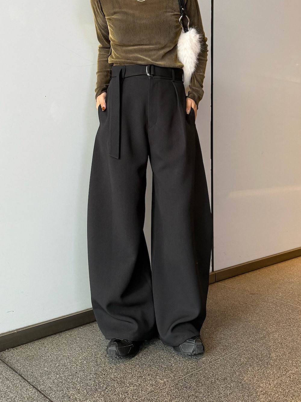 ブラック系のスラックス、ブラウン系のトートバッグ、グリーン系のTシャツ/カットソーを着用したレディースの秋コーディネートの6枚目の写真