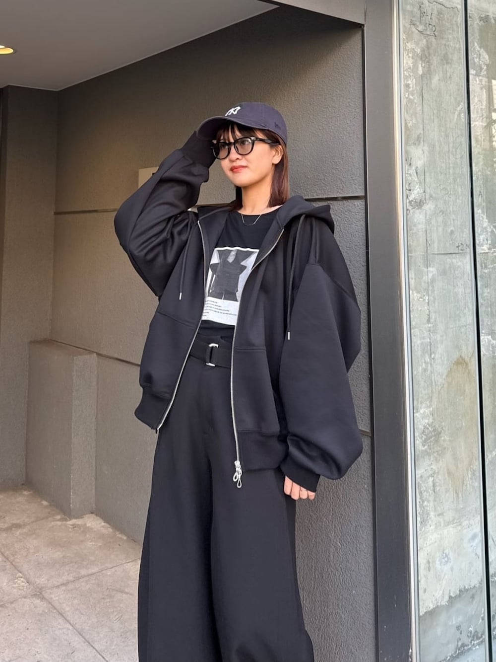 ブルー系のパーカー、ブラック系のスラックス、ブラック系のTシャツ/カットソーを着用したレディースの冬コーディネートの4枚目の写真