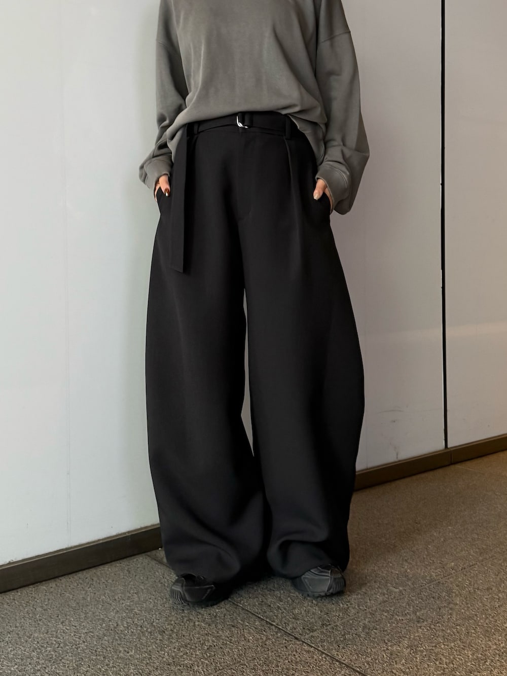 ブラック系のスラックス、ブラック系のスウェット、ブラック系のサングラスを着用したレディースの秋コーディネートの3枚目の写真