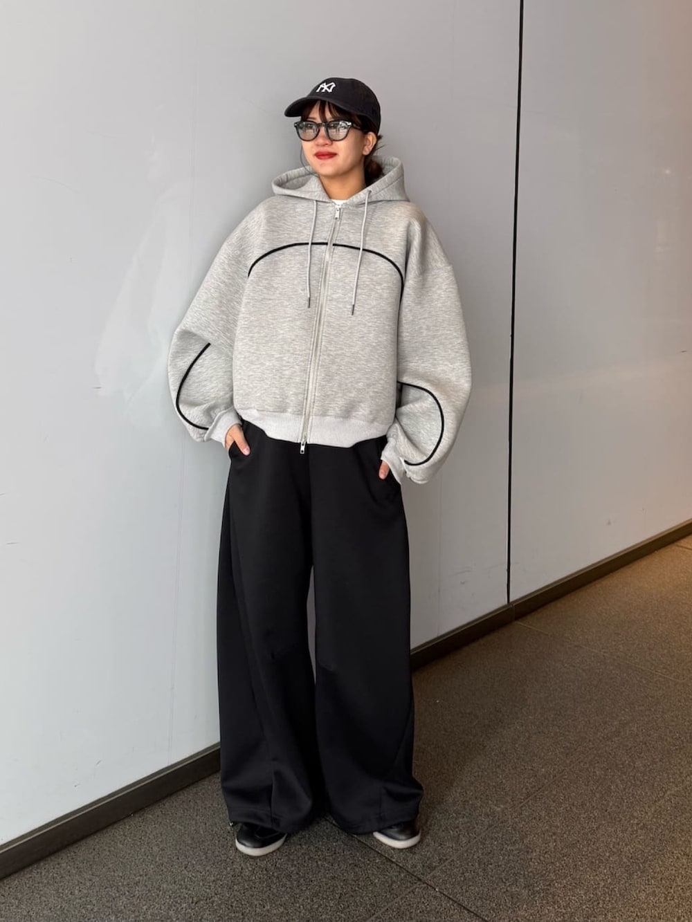 グレー系のパーカー、グレー系のその他パンツ、ブラック系のサングラスを着用したレディースの春コーディネートの6枚目の写真