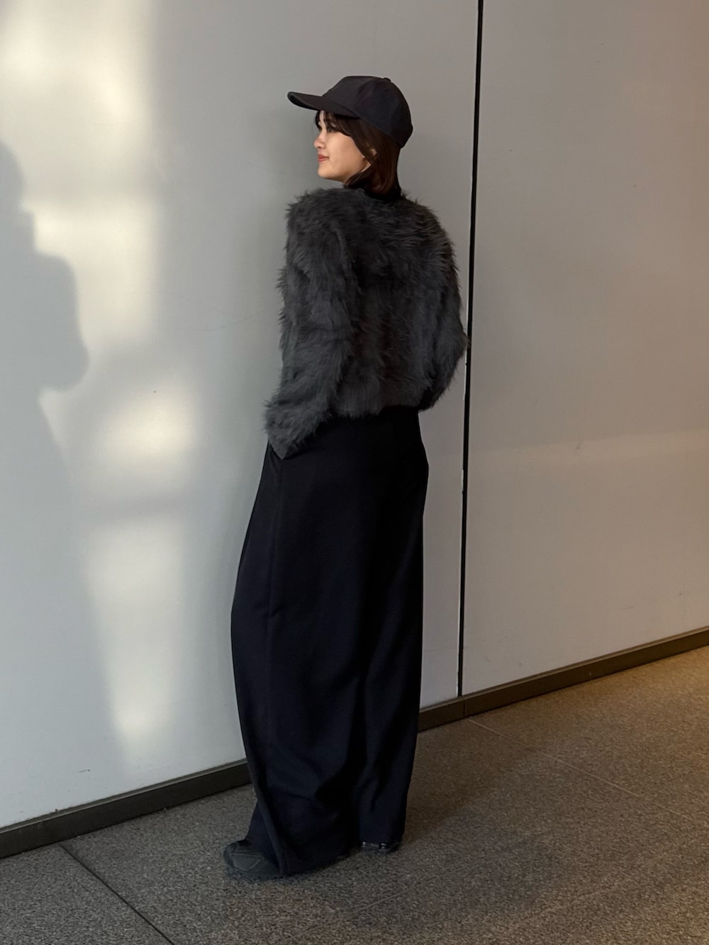 グレー系のニット/セーター、ブラック系のスラックスを着用したレディースの冬コーディネートの4枚目の写真