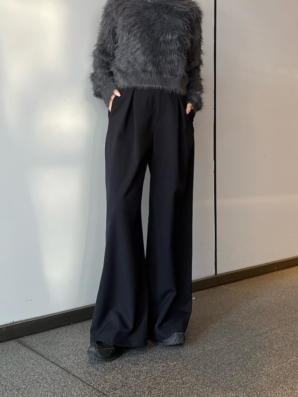 グレー系のニット/セーター、ブラック系のスラックスを着用したレディースの冬コーディネートの6枚目の写真