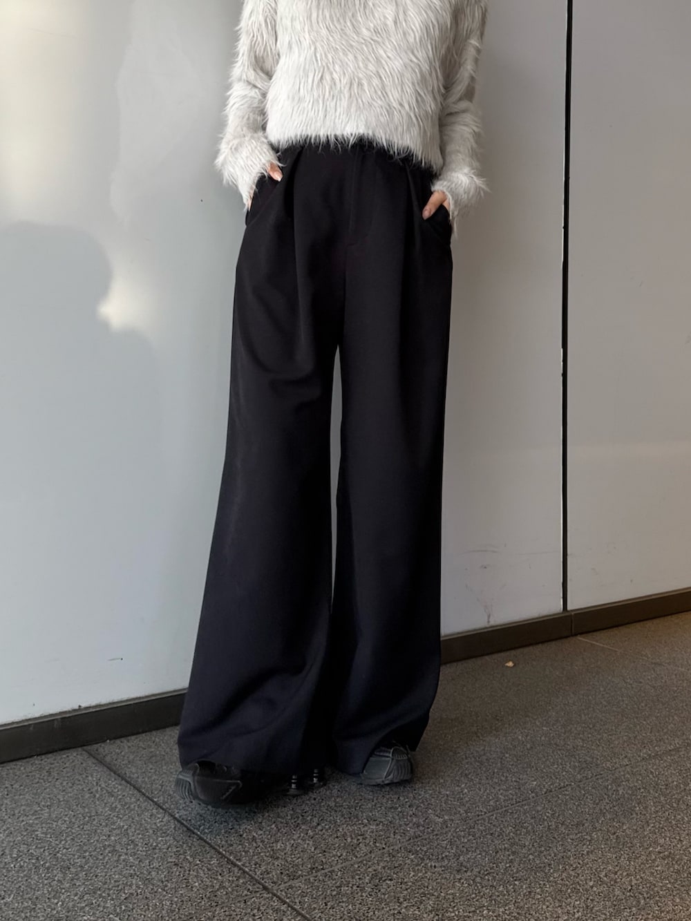 ブラック系のブルゾン、ブラック系のスラックス、グレー系のニット/セーターを着用したレディースの冬コーディネートの5枚目の写真