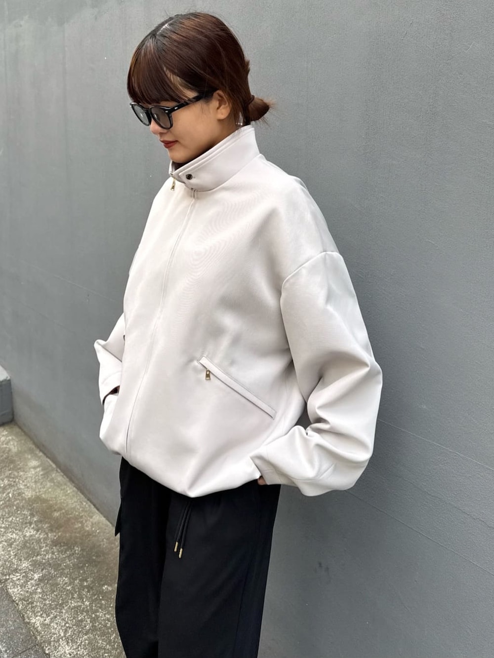 グレー系のブルゾン、ホワイト系のカーゴパンツを着用したレディースの冬コーディネートの2枚目の写真