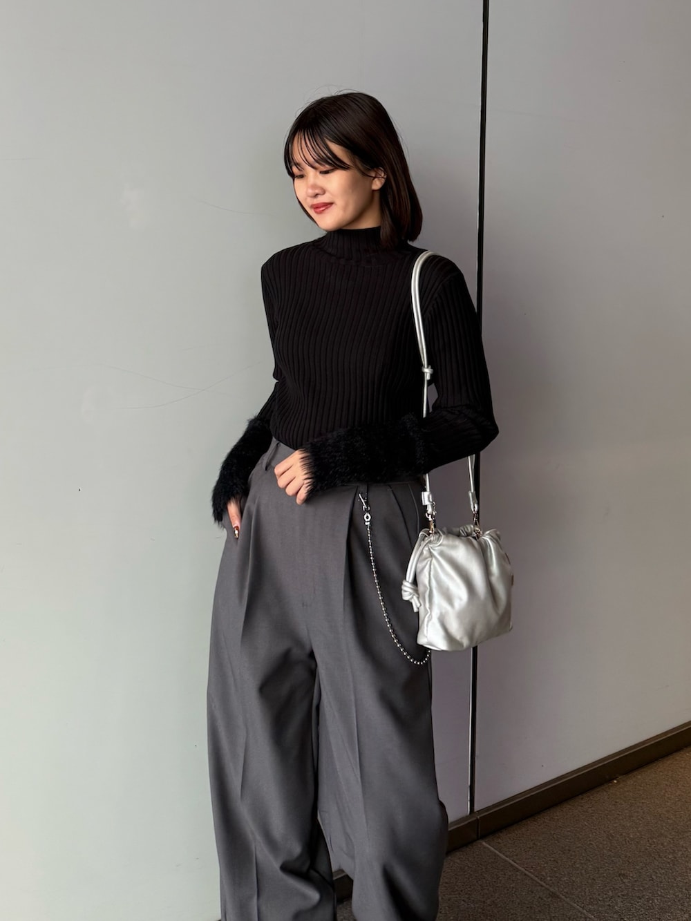グレー系のスラックス、シルバー系のショルダーバッグ、ブラック系のTシャツ/カットソーを着用したレディースの秋コーディネートの5枚目の写真