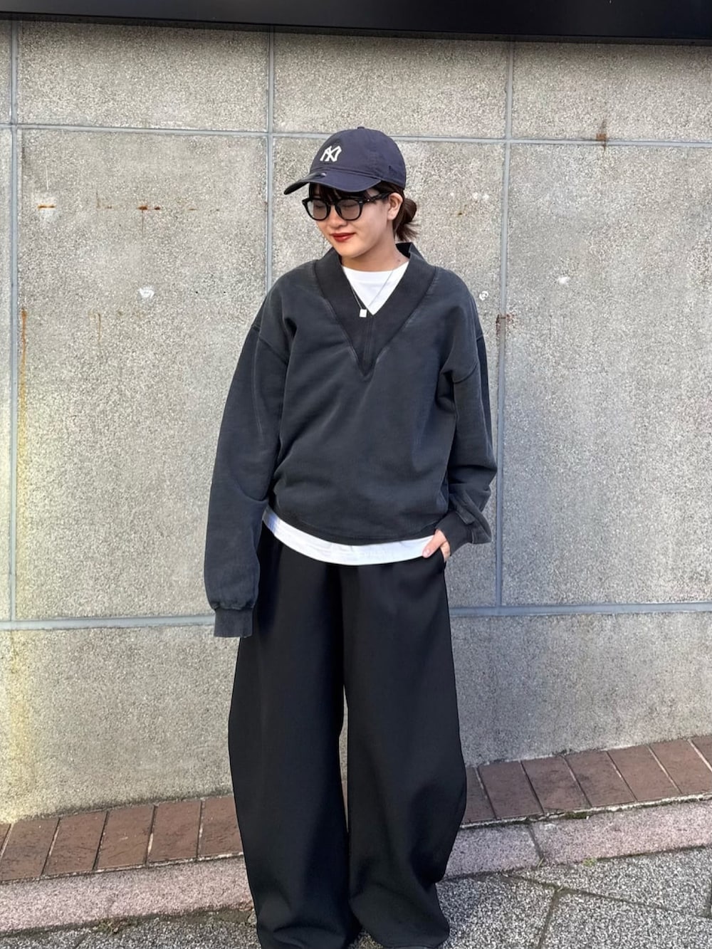 ブラック系のスウェット、ブラック系のスラックス、ブラック系のサングラスを着用したレディースの冬コーディネートの7枚目の写真