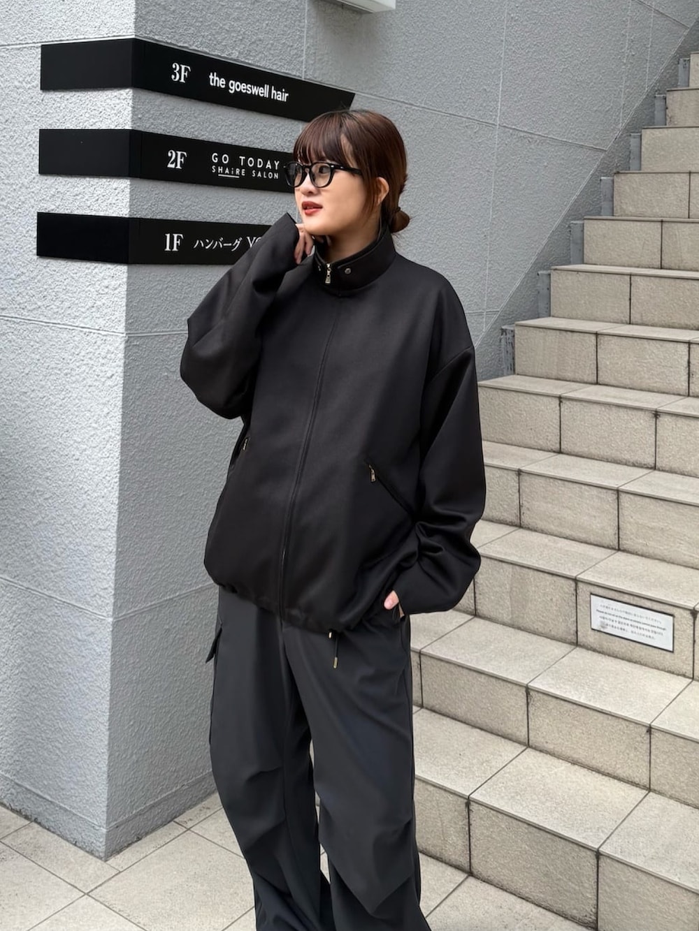 グレー系のブルゾン、ホワイト系のカーゴパンツを着用したレディースの冬コーディネートの2枚目の写真