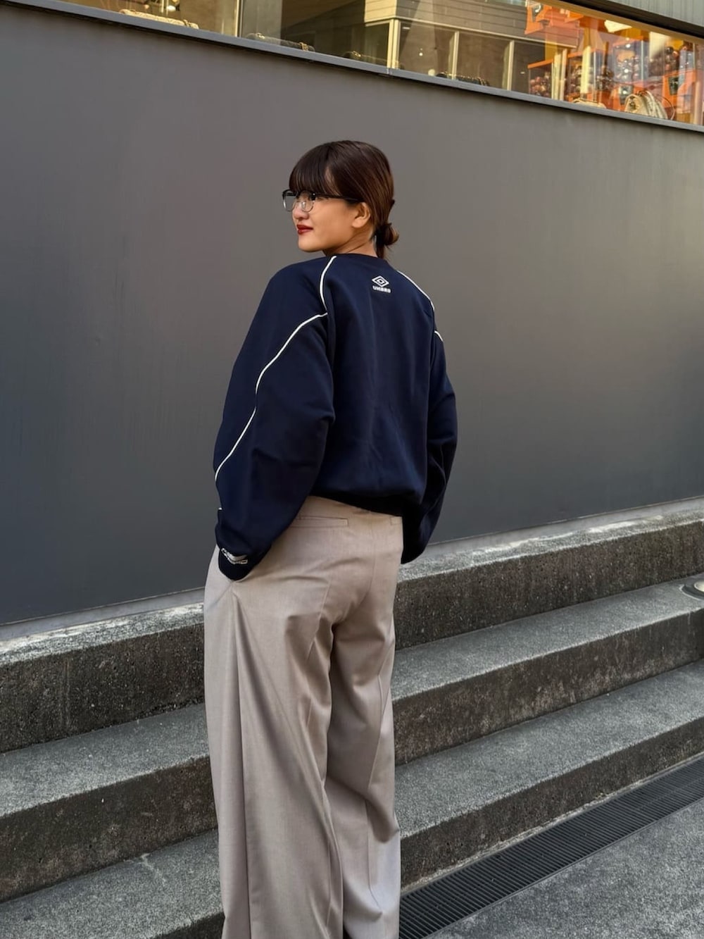 ブルー系のスウェット、グレー系のスラックスを着用したレディースの冬コーディネートの3枚目の写真