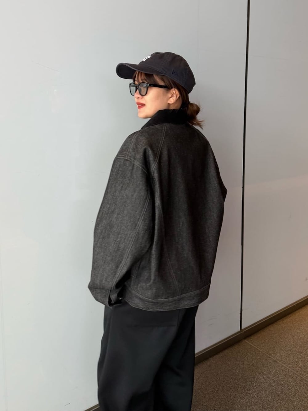 ブラック系のデニムジャケット、グレー系のその他パンツ、ブラック系のサングラスを着用したレディースの春コーディネートの5枚目の写真