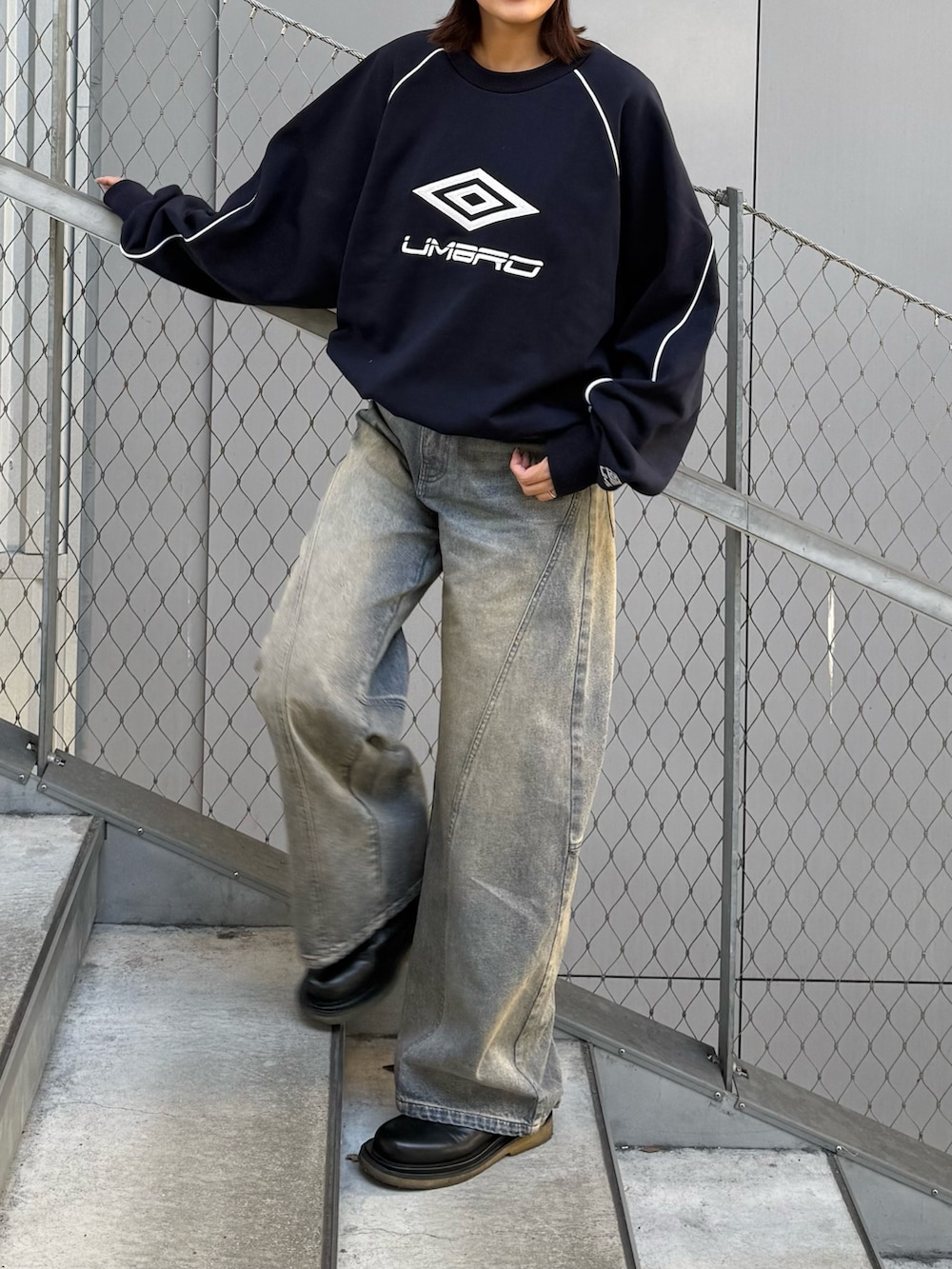 ブルー系のデニムパンツ、ブルー系のスウェット、ブラック系のサングラスを着用したレディースの冬コーディネートの3枚目の写真