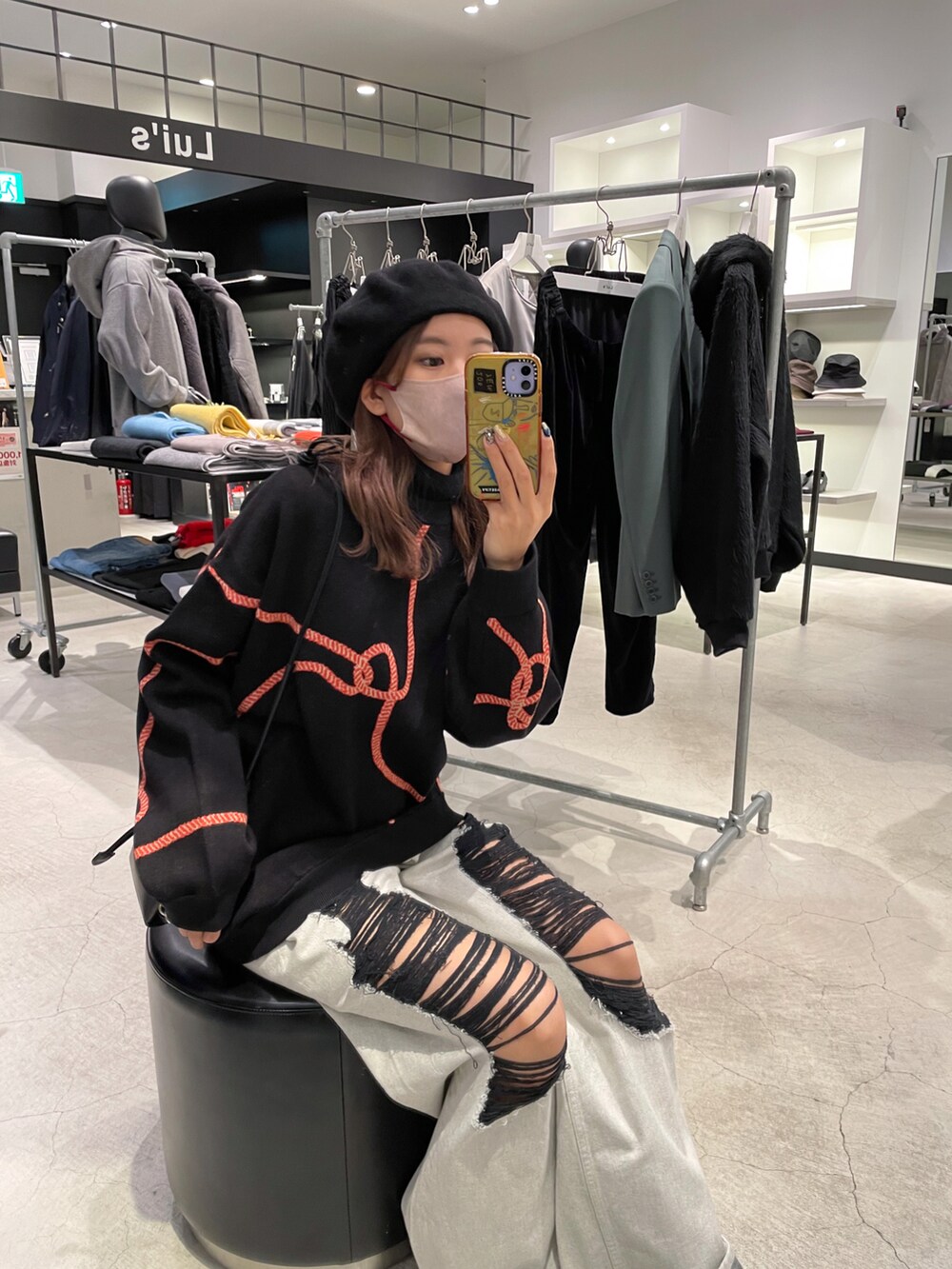 ブラック系のニット/セーター、ブラック系のボディバッグ/ウエストポーチ、ブルー系のデニムパンツを着用したレディースの冬コーディネートの2枚目の写真