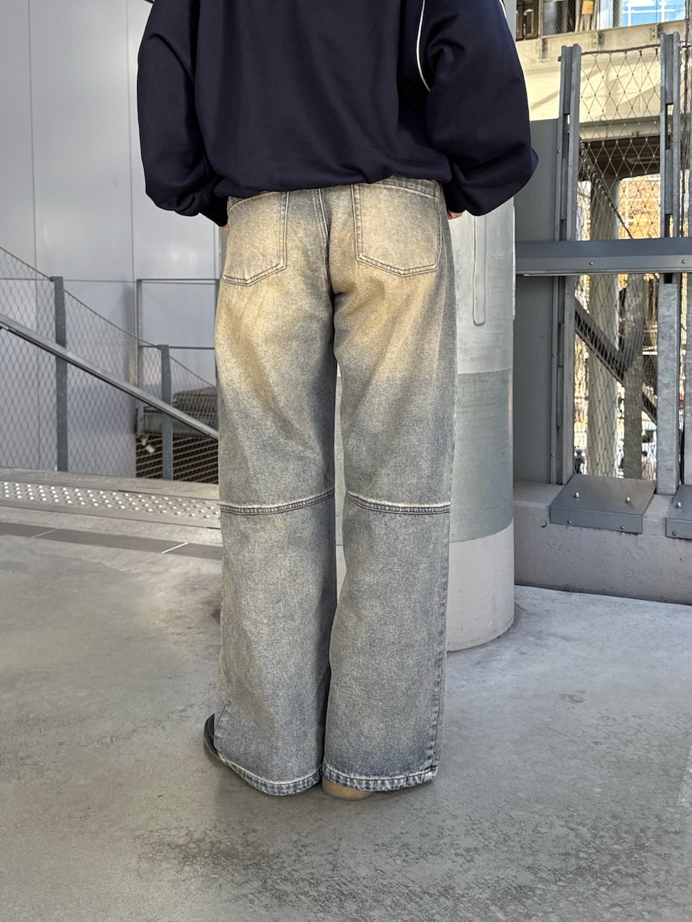 ブルー系のデニムパンツ、ブルー系のスウェット、ブラック系のサングラスを着用したレディースの冬コーディネートの6枚目の写真