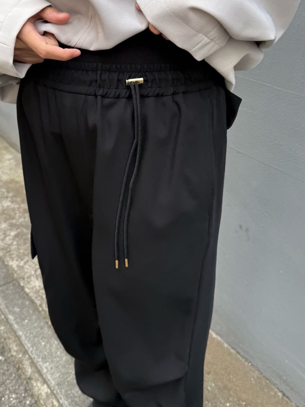 グレー系のブルゾン、ホワイト系のカーゴパンツを着用したレディースの冬コーディネートの5枚目の写真