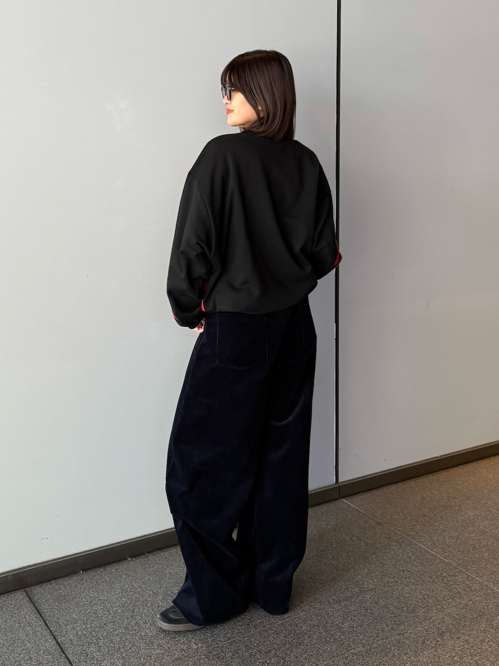 ブラック系のスウェット、ブルー系のその他パンツ、ブラック系のサングラスを着用したレディースの秋コーディネートの5枚目の写真