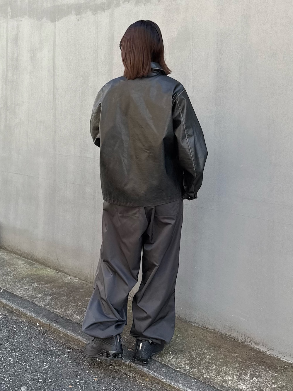 ブラック系のブルゾン、ホワイト系のその他パンツを着用したレディースの秋コーディネートの4枚目の写真