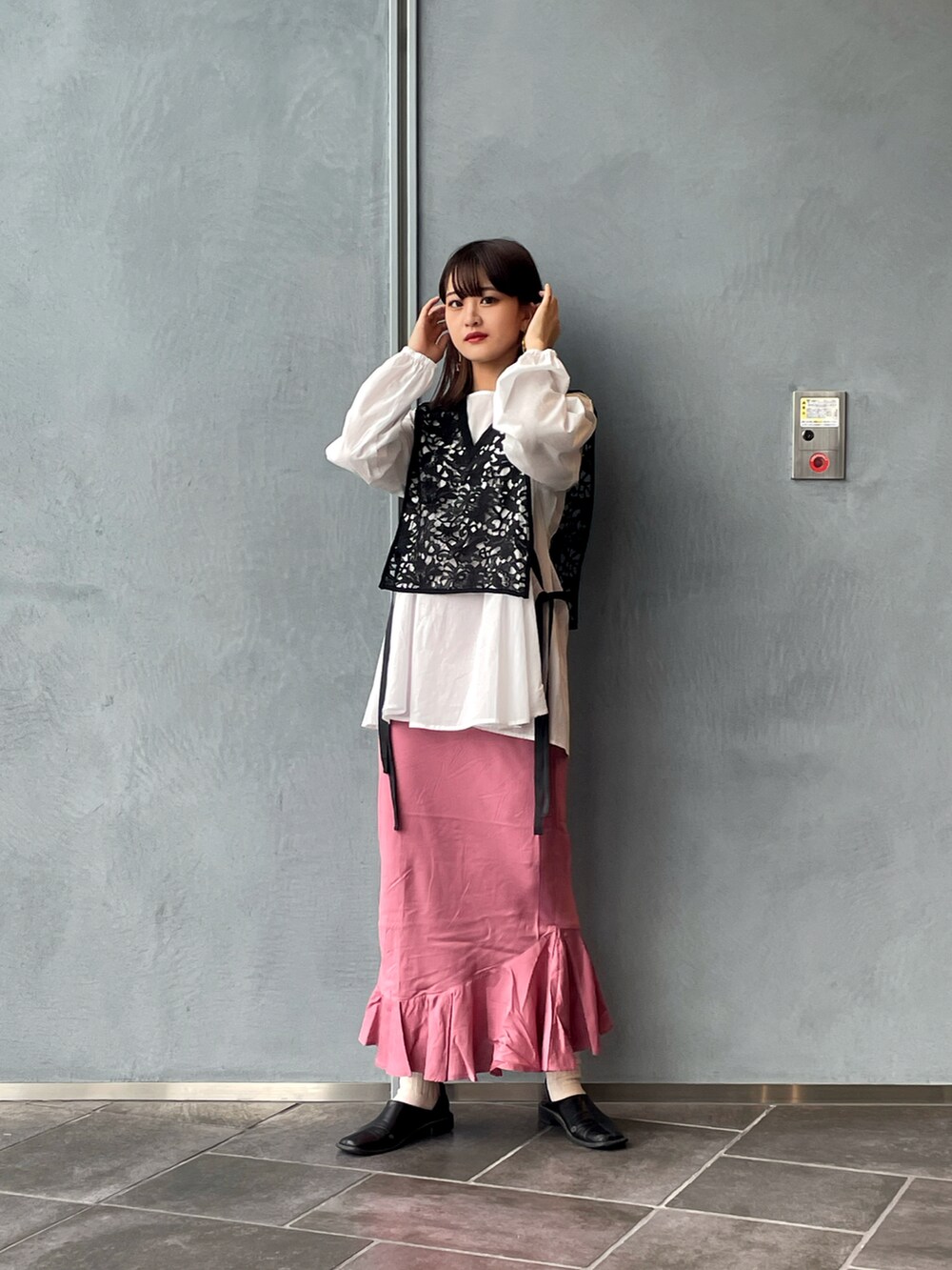 ブラック系のシャツ/ブラウス、ピンク系のスカート、ブラック系のパンプスを着用したレディースの春コーディネートの3枚目の写真