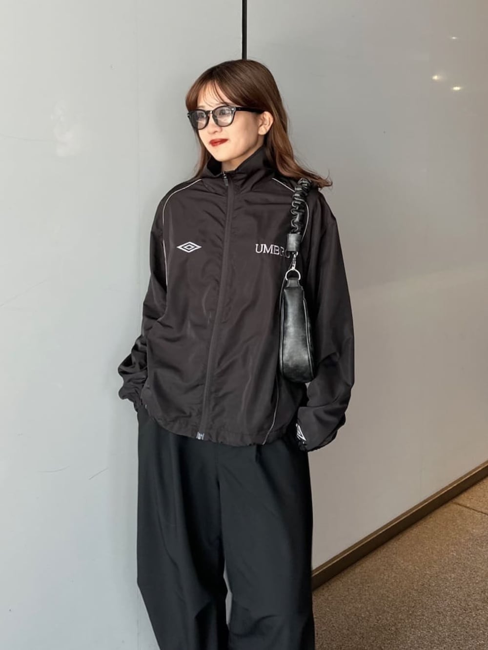 ブラック系のその他パンツ、ブラック系のショルダーバッグ、ブラック系のブルゾンを着用したレディースの夏コーディネートの2枚目の写真