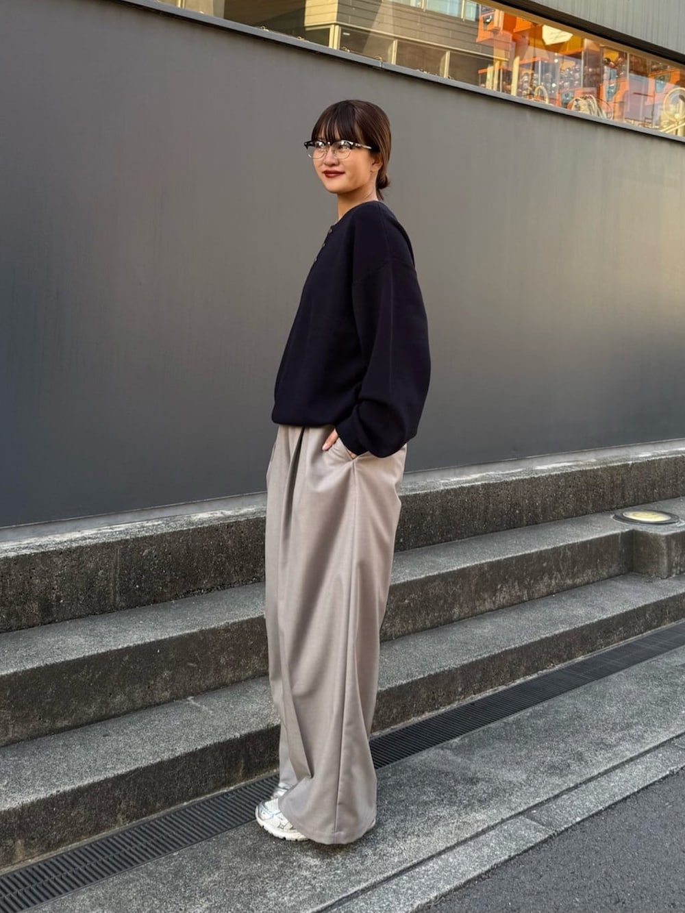 ブルー系のニット/セーター、グレー系のスラックスを着用したレディースの冬コーディネートの4枚目の写真