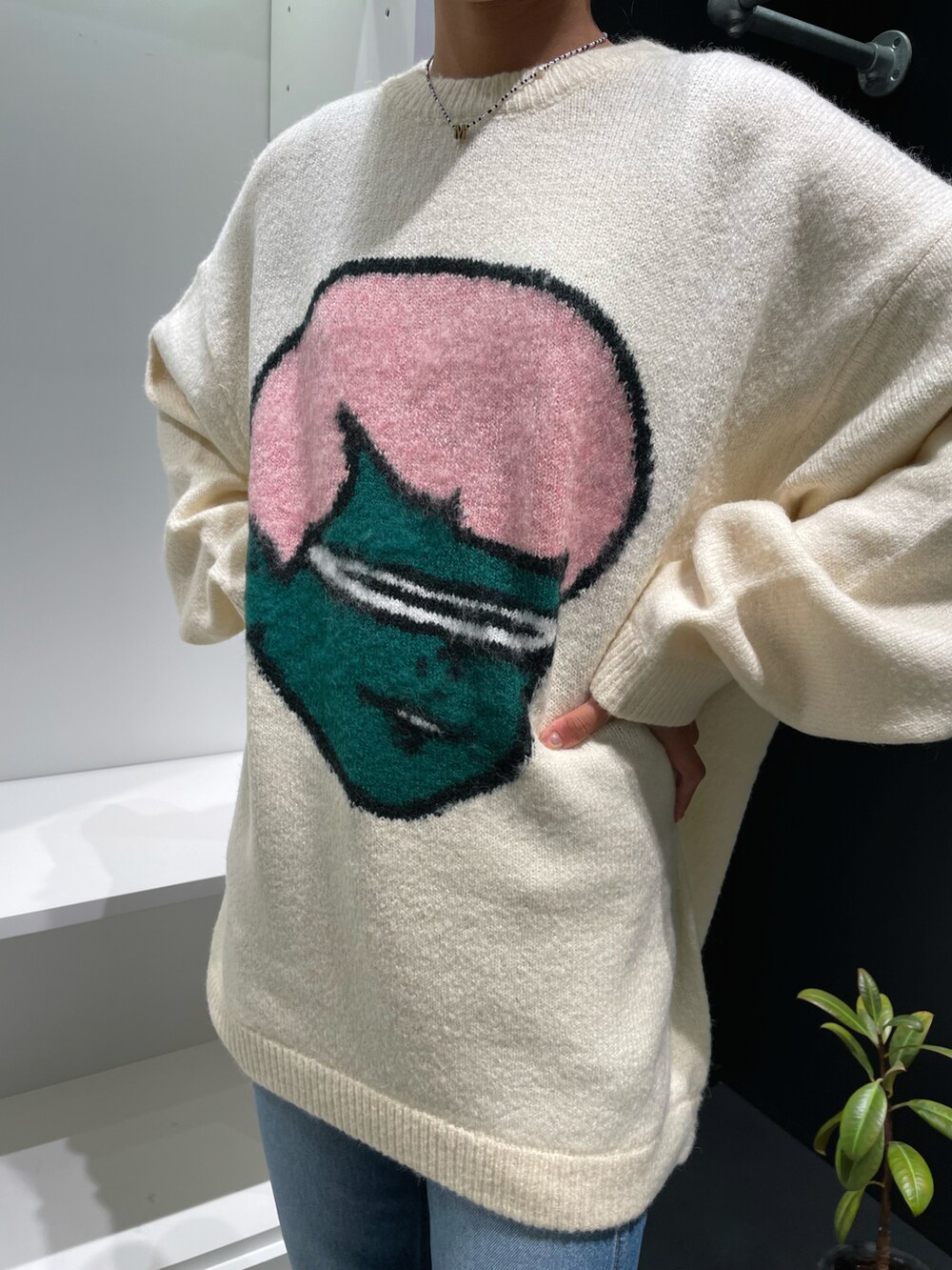 ホワイト系のニット/セーター、ブルー系のデニムパンツを着用したレディースの秋コーディネートの3枚目の写真