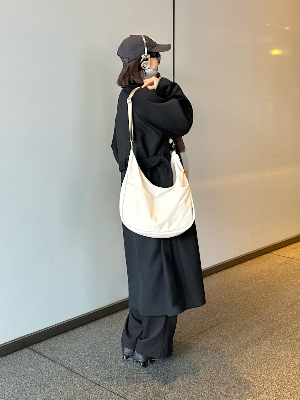 ブラック系のチェスターコート、ブラック系のその他アウター、ブラウン系のマフラーを着用したレディースの秋コーディネートの4枚目の写真