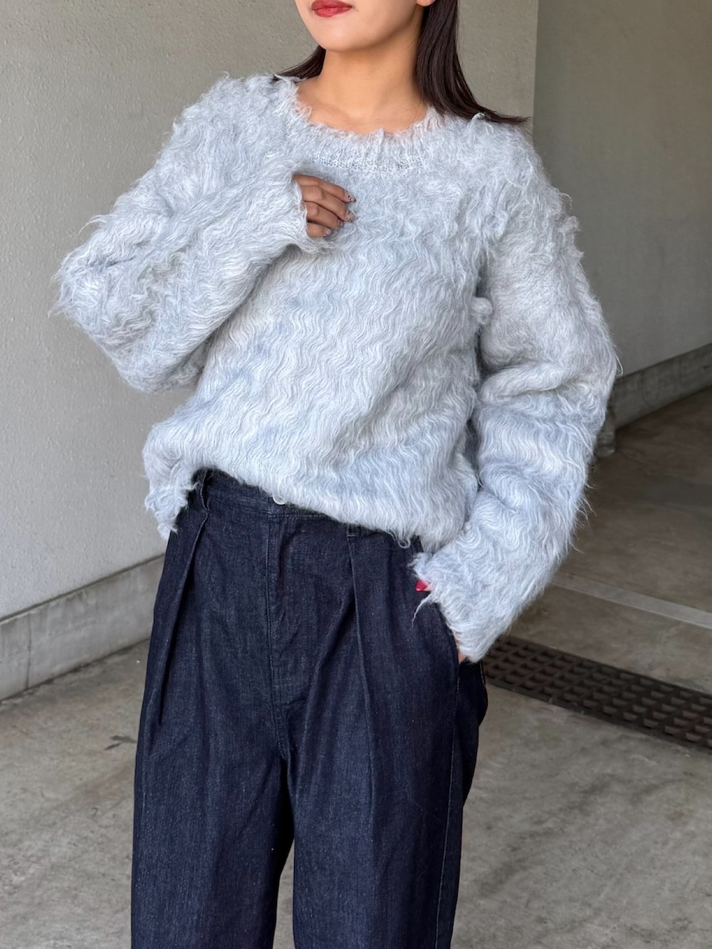 グレー系のニット/セーター、ブルー系のデニムパンツ、ブラック系のサングラスを着用したレディースの秋コーディネートの4枚目の写真