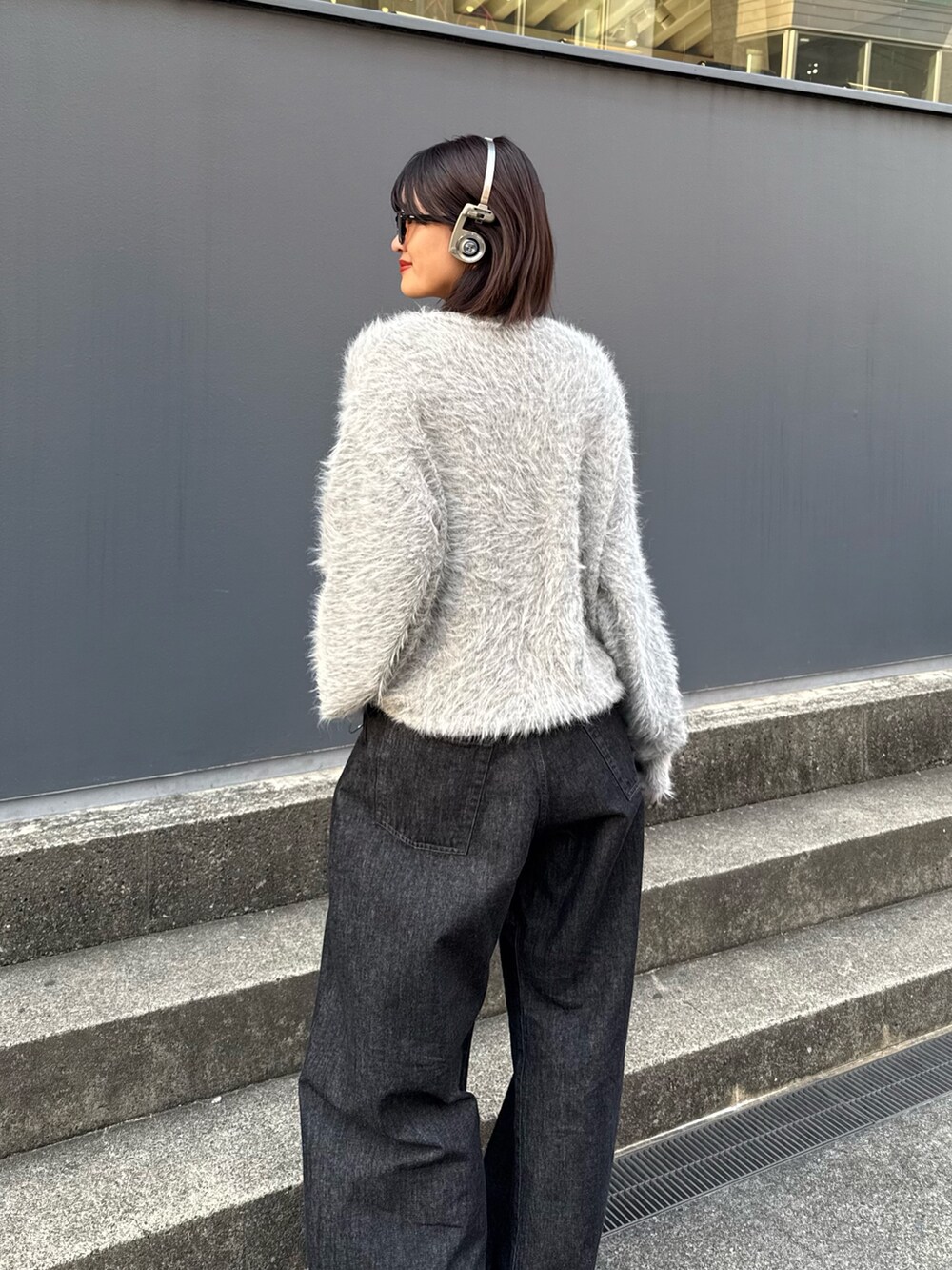 グレー系のニット/セーター、ブラック系のデニムパンツを着用したレディースの秋コーディネートの6枚目の写真