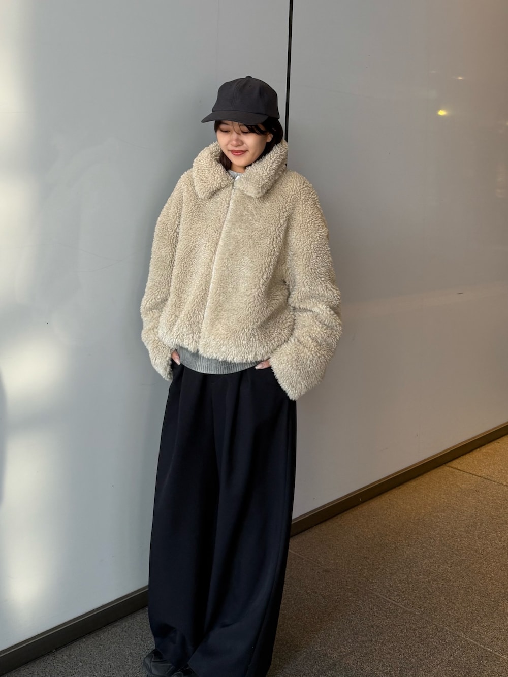 ベージュ系のブルゾン、ブラック系のスラックスを着用したレディースの冬コーディネートの2枚目の写真