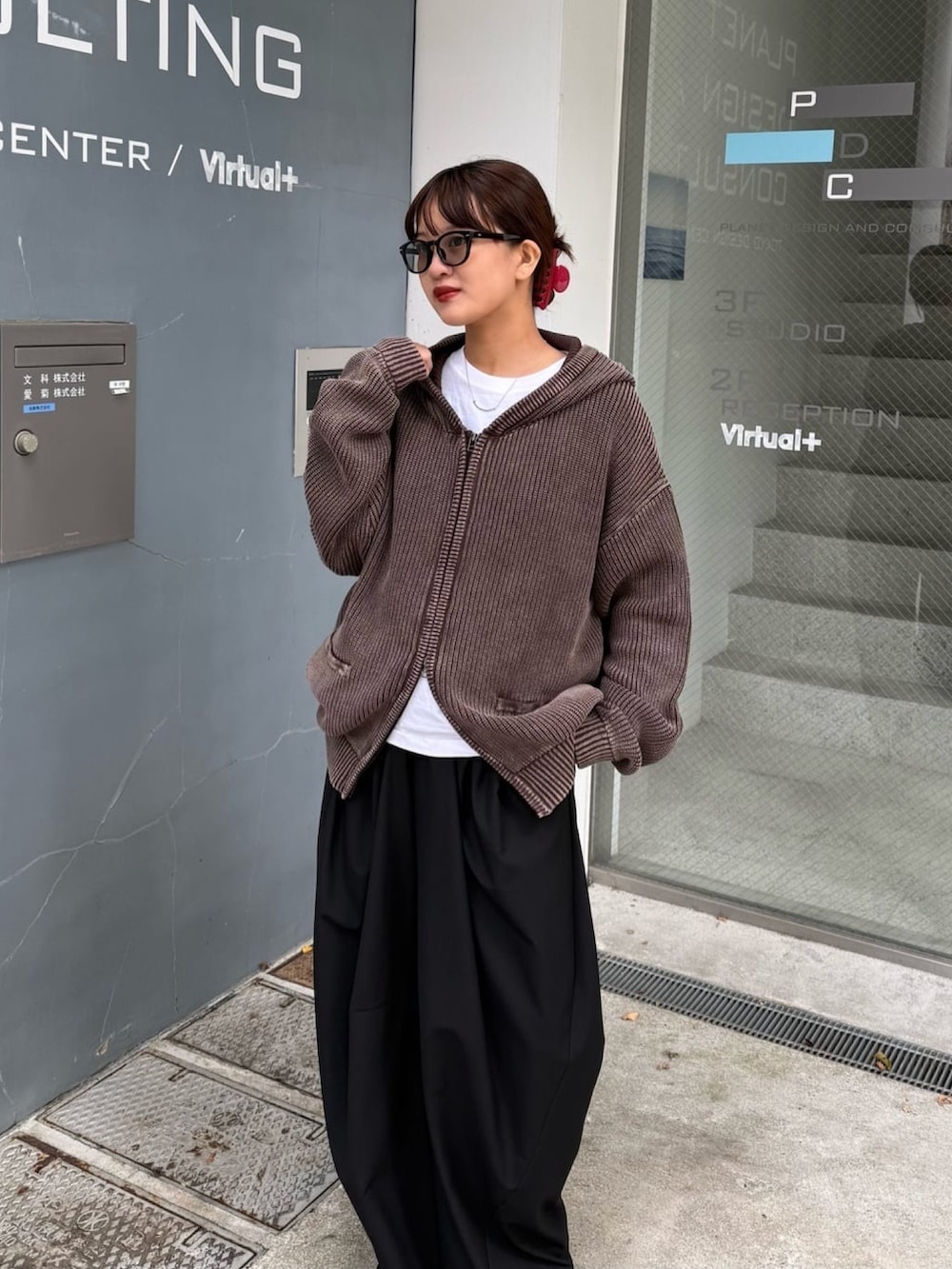 ブラウン系のパーカー、グレー系のスラックスを着用したレディースの春コーディネートの2枚目の写真