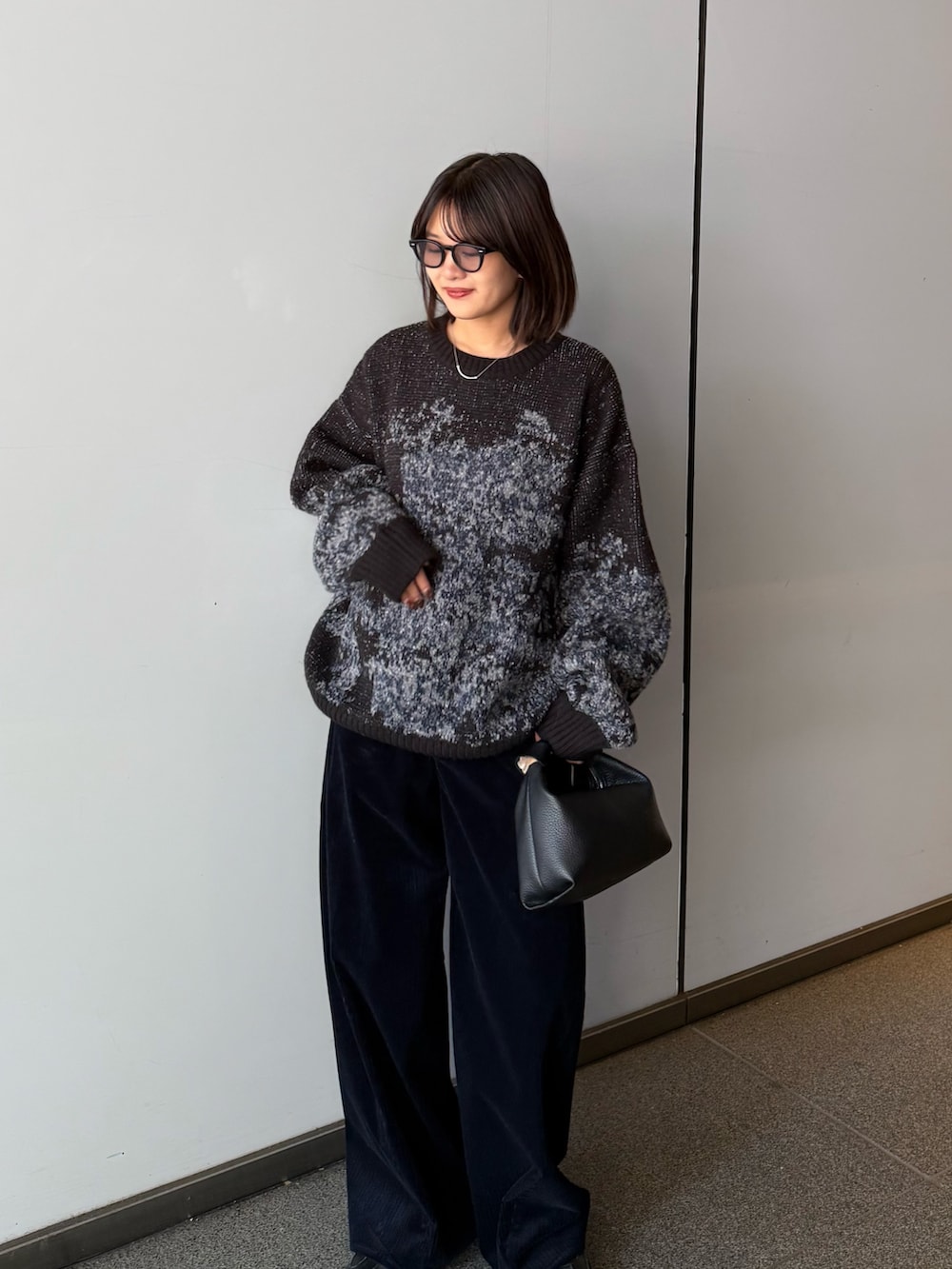 ブラック系のニット/セーター、ブラック系のトートバッグ、ブルー系のその他パンツを着用したレディースの秋コーディネートの2枚目の写真