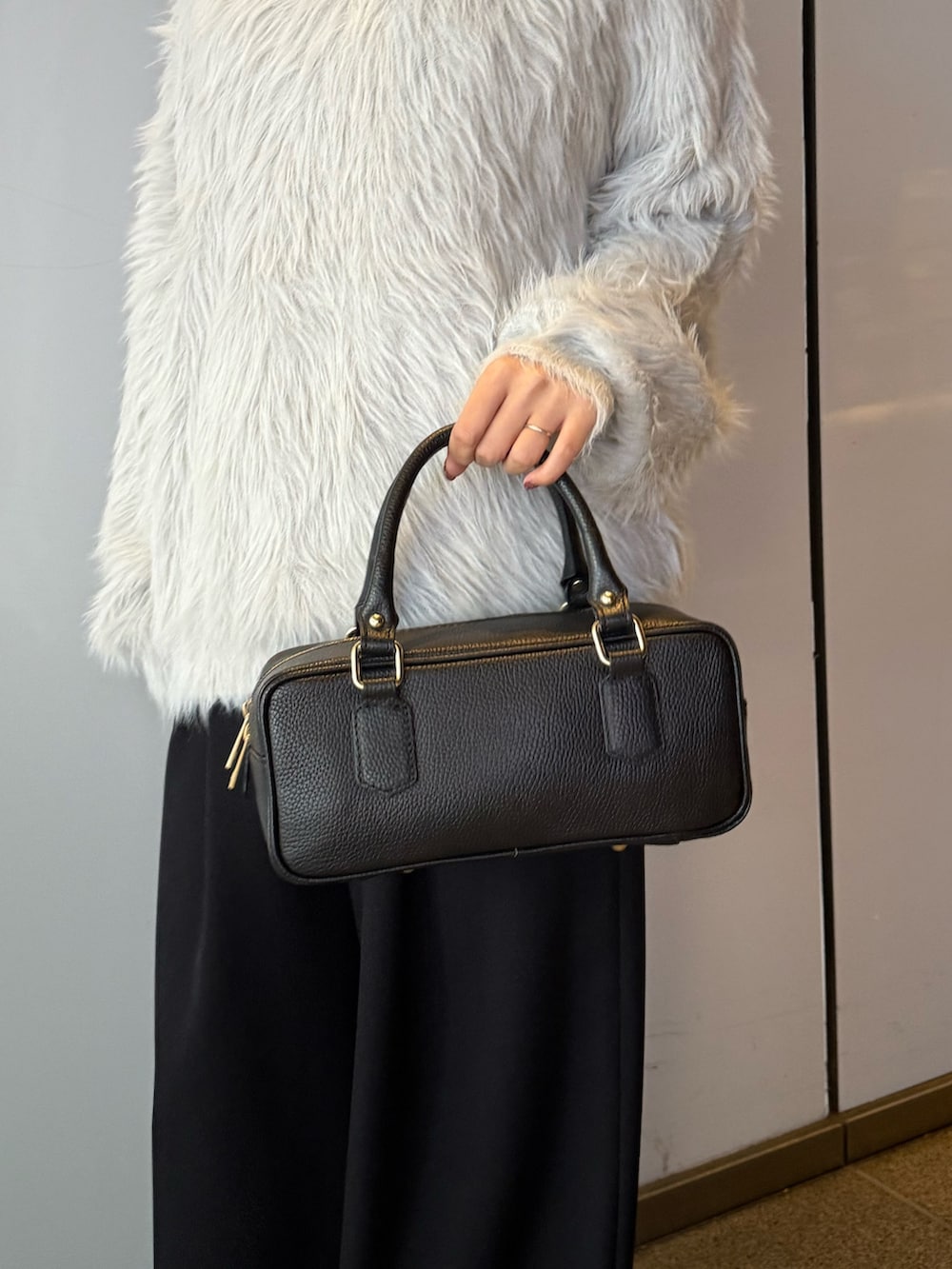 ブラック系のスラックス、ブラック系のトートバッグ、グレー系のニット/セーターを着用したレディースの冬コーディネートの6枚目の写真